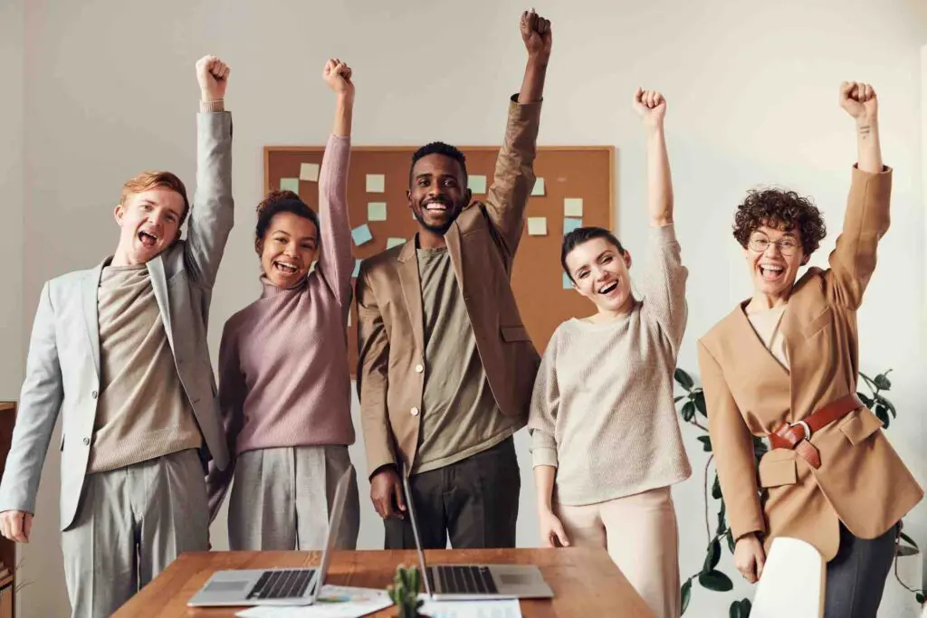 5 employees with their arms in the air