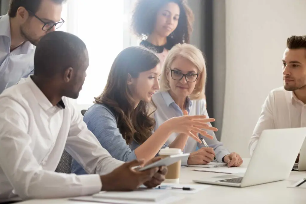 Employees sitting around a laptop talking