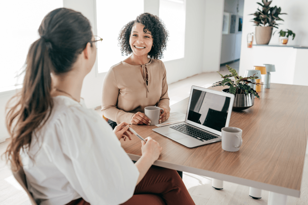 Manager and employee sitting at desk talking